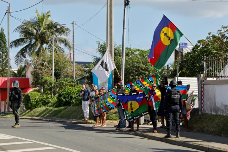 Des manifestants avec des drapeaux kanak sur le parcours du cortège du président de la République Emmanuel Macron à Nouméa, en Nouvelle-Calédonie, le 23 mai 2024 © Ludovic MARIN