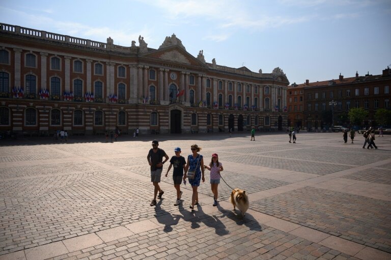 Une famille traverse la place du Capitole à Toulouse, le 28 juillet 2024 © Ed JONES