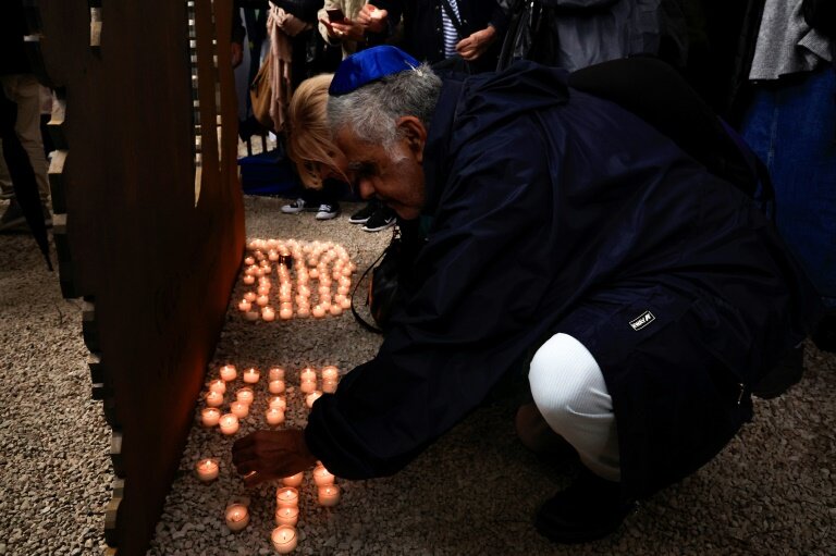 Une personne dépose une bougie devant une œuvre d'art commémorative dévoilée lors d'une cérémonie d'hommage aux victimes de l'attaque du 7 octobre contre Israël par le Hamas à Nice, le 7 octobre 2024 © Valery HACHE