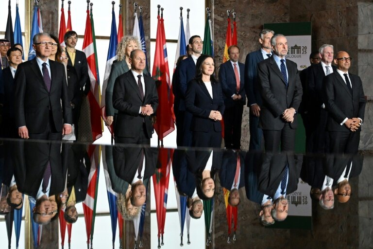 Photo de famille rassemblant des participants au dialogue de Pertersberg sur le climat à Berlin le 26 mars 2025, parmi lesquels figurent au premier plan la ministre allemande des Affaires étrangères Annalena Baerbock et le chancelier Olaf Scholz © RALF HIRSCHBERGER