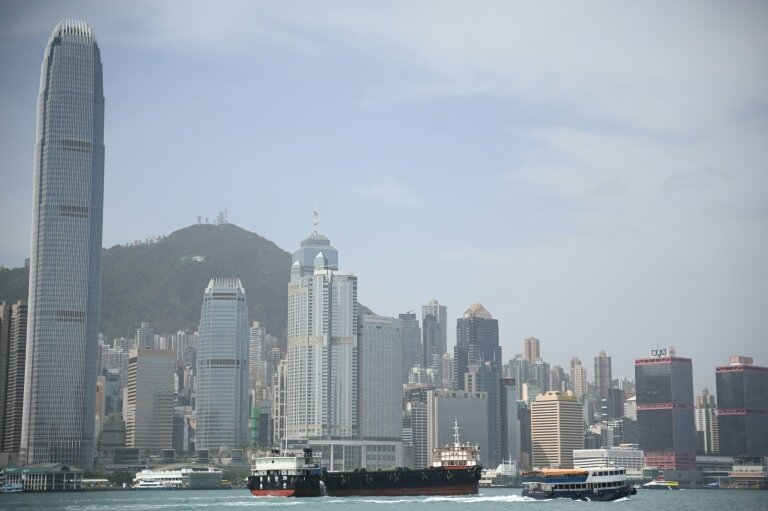 Une barge porte-conteneurs à vide traverse le port de Victoria à Hong Kong, le 16 avril 2025 © Peter PARKS