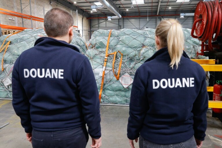 Des douaniers devant des colis de fret aérien dans un entrepôt de l'aéroport Roissy-Charles-de-Gaulle, au nord de Paris, le 29 avril 2025 © GEOFFROY VAN DER HASSELT