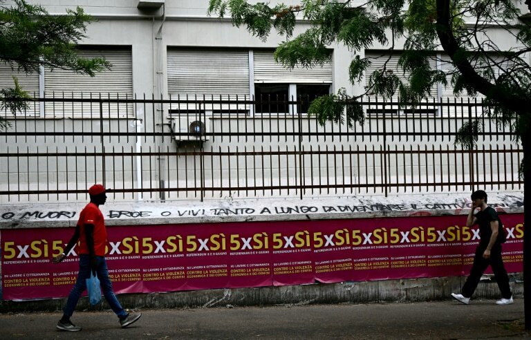 Des gens passent devant des affiches invitant à voter pour le référendum, à Rome, le 5 juin 2025 © Filippo MONTEFORTE