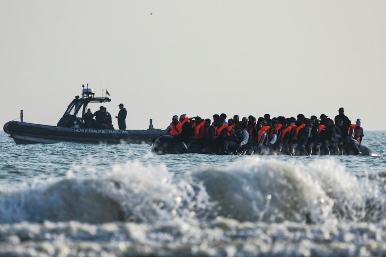Un bateau de la gendarmerie maritime se tient à proximité d'une embarcation clandestine de migrants tentant de gagner l'Angleterre, le 13 juin 2024 à Gravelines, dans le nord de la France © Sameer Al-DOUMY