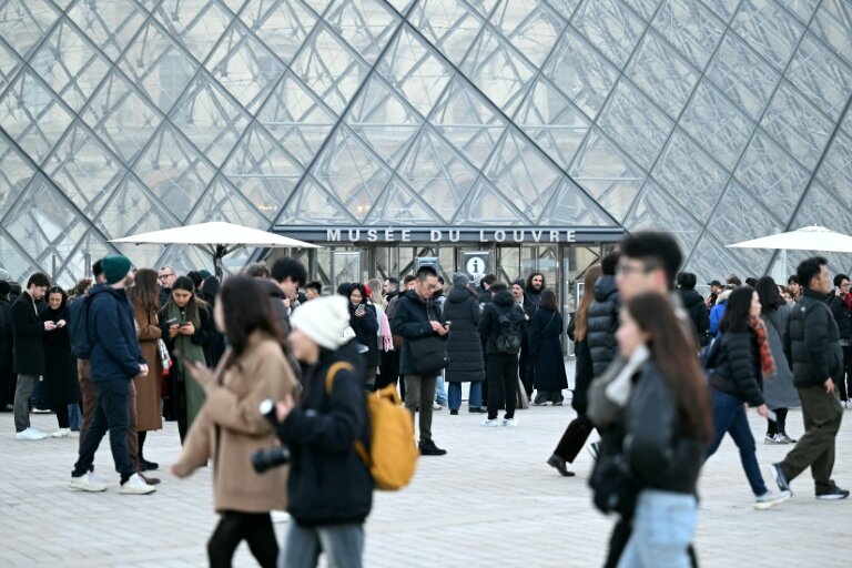 Des visiteurs devant la pyramide du Louvre le 15 décembre 2025 à Paris © Blanca CRUZ