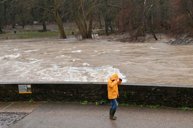 Un passant sur les berges de l'Hérault, qui a débordé suite aux fortes pluies à Laroque, le 22 décembre 2025 © Sylvain THOMAS