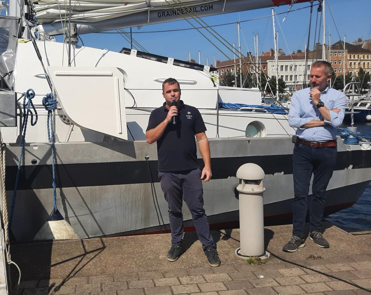 Loïc Briand, directeur général de Grain de Sail Shipping, et Jacques Barreau, cofondateur de Grain de Sail, devant leur voilier qui fait escale à Dunkerque jusqu'au 11 septembre afin de sensibiliser les habitants du territoire à leur projet.