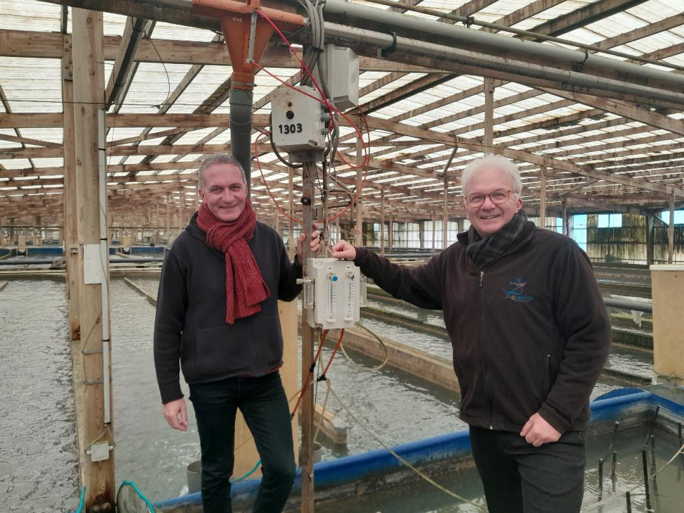 Bertrand Ritter, directeur d'Aquanord, pose à côté des bassins d'élevage de daurades avec Philippe Riera, dirigeant-fondateur du groupe Gloria Maris, propriétaire d'Aquanord depuis 2013.