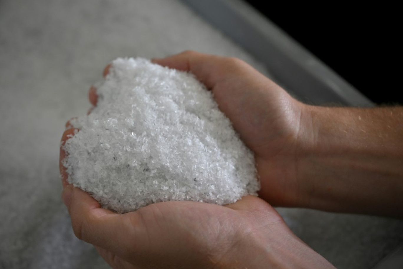 Un employé tient dans ses mains du plastique médical obtenu à partir du recylage de matériel dentaire dans une usine à Salon-de-Provence, dans le sud de la France, le 20 juin 2023 © Nicolas TUCAT
