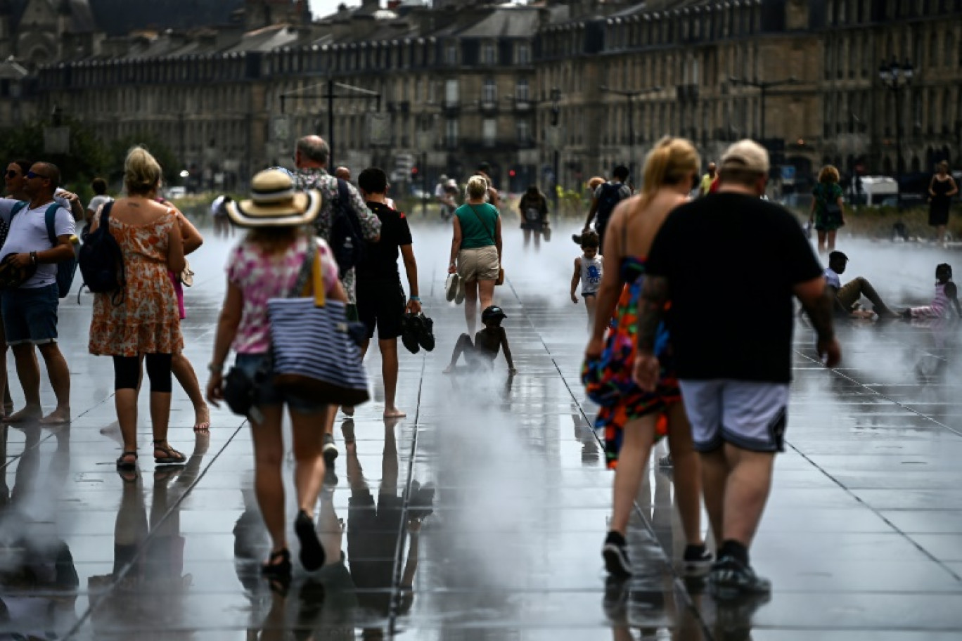 Des passants se rafraîchissent sur le Miroir d'Eau à Bordeaux, le 23 août 2023 pendant une vague de chaleur en France © Christophe ARCHAMBAULT