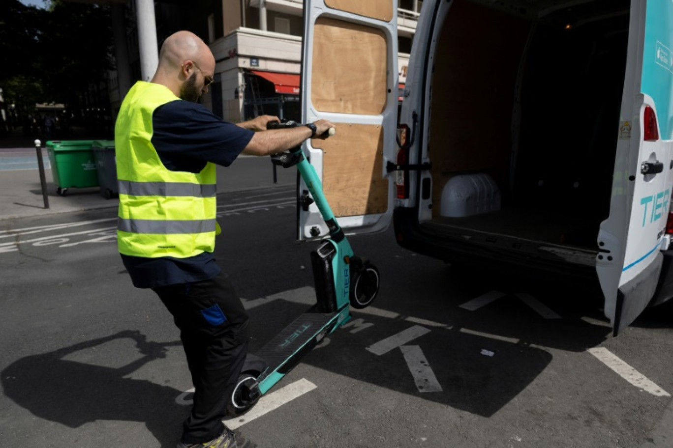 Un employé charge une trottinette électrique dans une camionnette, le 23 août 2023 à Paris © ALAIN JOCARD