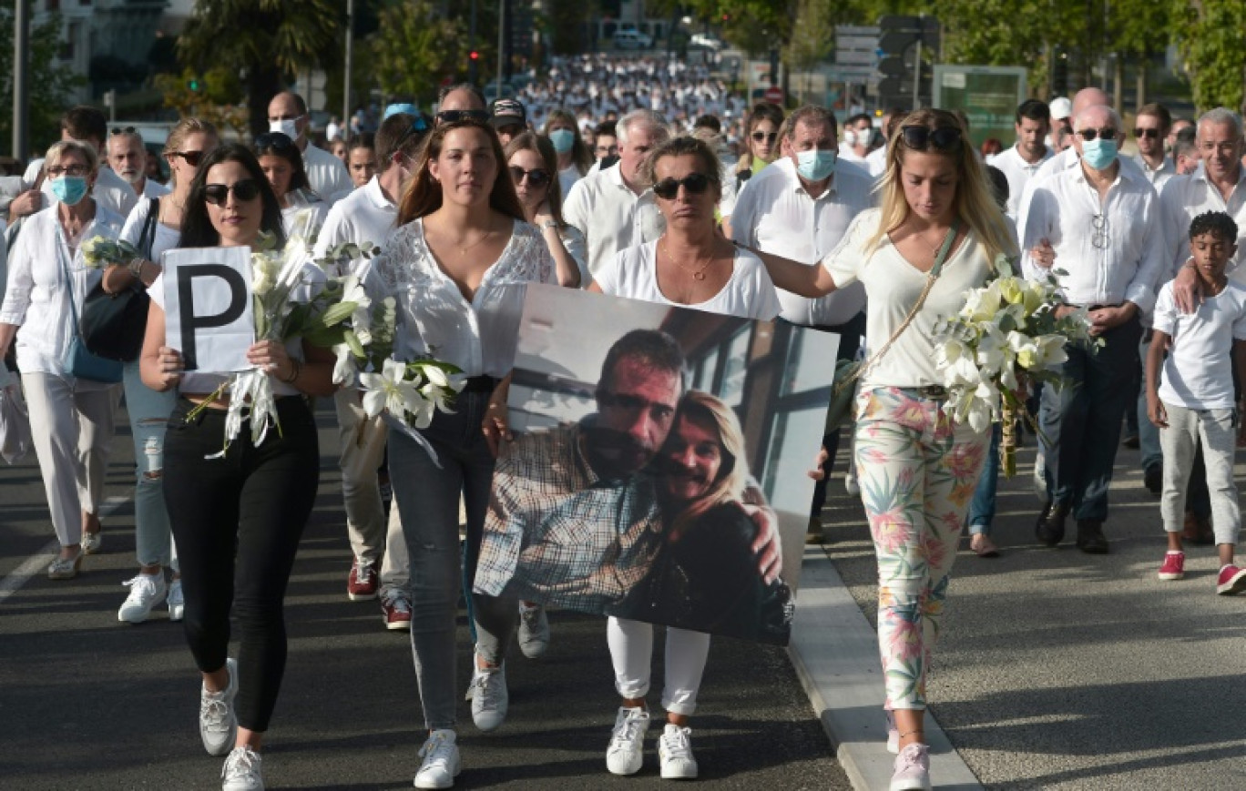 Véronique Monguillot (C) tient une photo de son mari lors d'une marche blanche le 8 juillet 2020 à Bayonne en hommage à ce chauffeur de bus mortellement frappé pendant son service © Iroz Gaizka