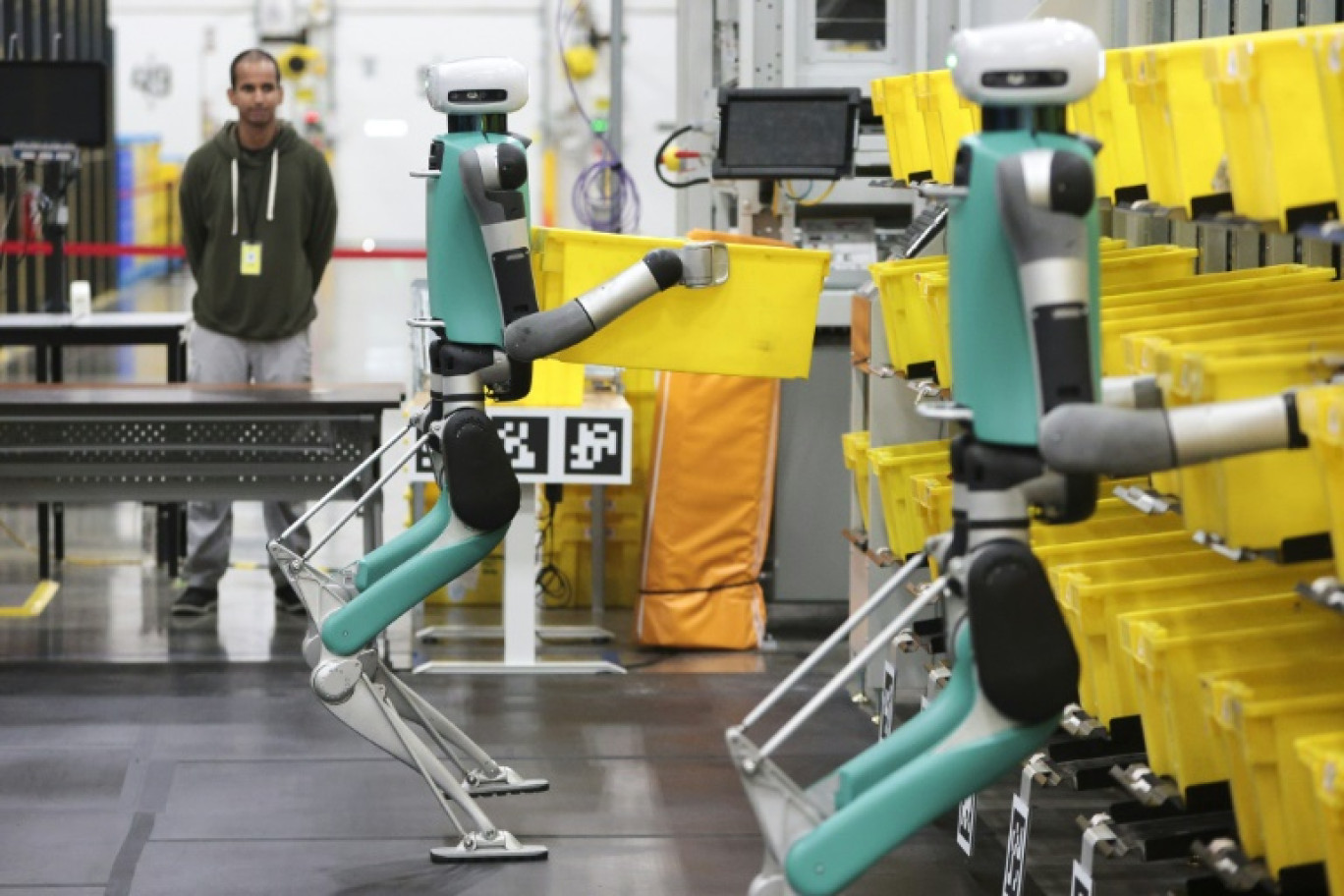 Des robots bipèdes déplacent des conteneurs lors d'un test de manipulation mobile au centre de distribution BFI1 d'Amazon, le 18 octobre 2023 à Sumner © Jason Redmond