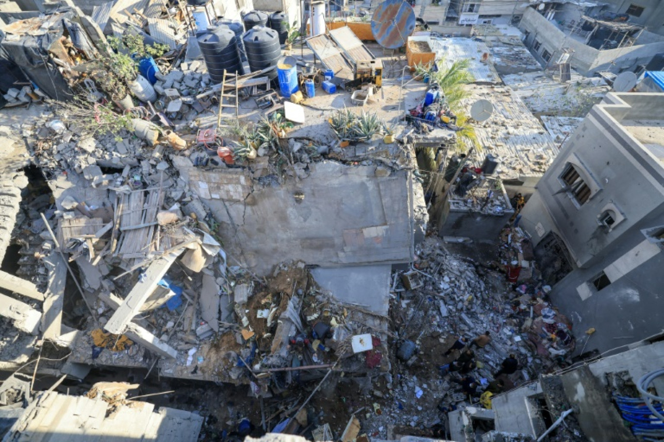 Des Palestiniens dans les décombres d'un bâtiment détruit lors de frappes israéliennes à Rafah, dans le sud de la bande de Gaza, le 7 décembre 2023 © MAHMUD HAMS