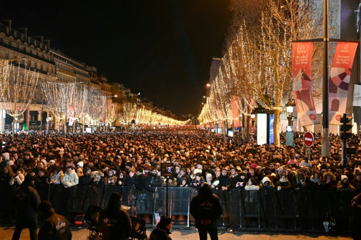 Des personnes se rassemblent sur l'avenue des Champs-Elysées pour les célébrations du Nouvel An à Paris, le 31 décembre 2023 © Bertrand GUAY