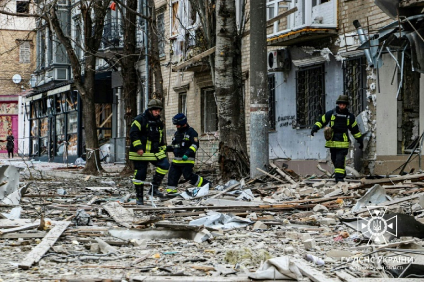 Photo diffusée par les services d'urgence ukrainiens, le 2 février 2024, de sauveteurs à l'extérieur de bâtiments endommagés par une frappe aérienne sur le centre de Kherson, dans le sud de l'Ukraine © Handout