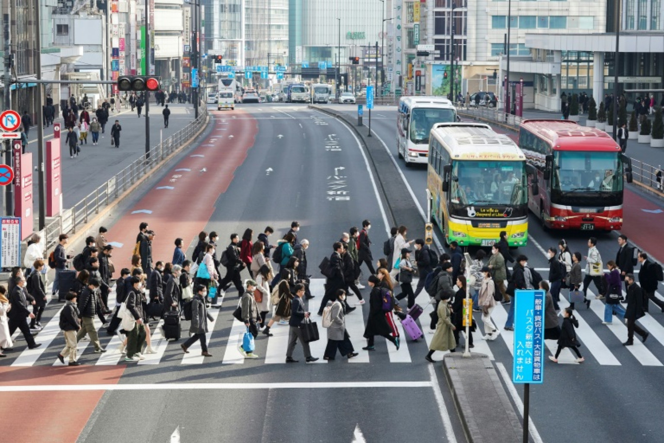 Des employés de bureau traversent un passage piéton à Tokyo, le 15 février 2024 © Kazuhiro NOGI