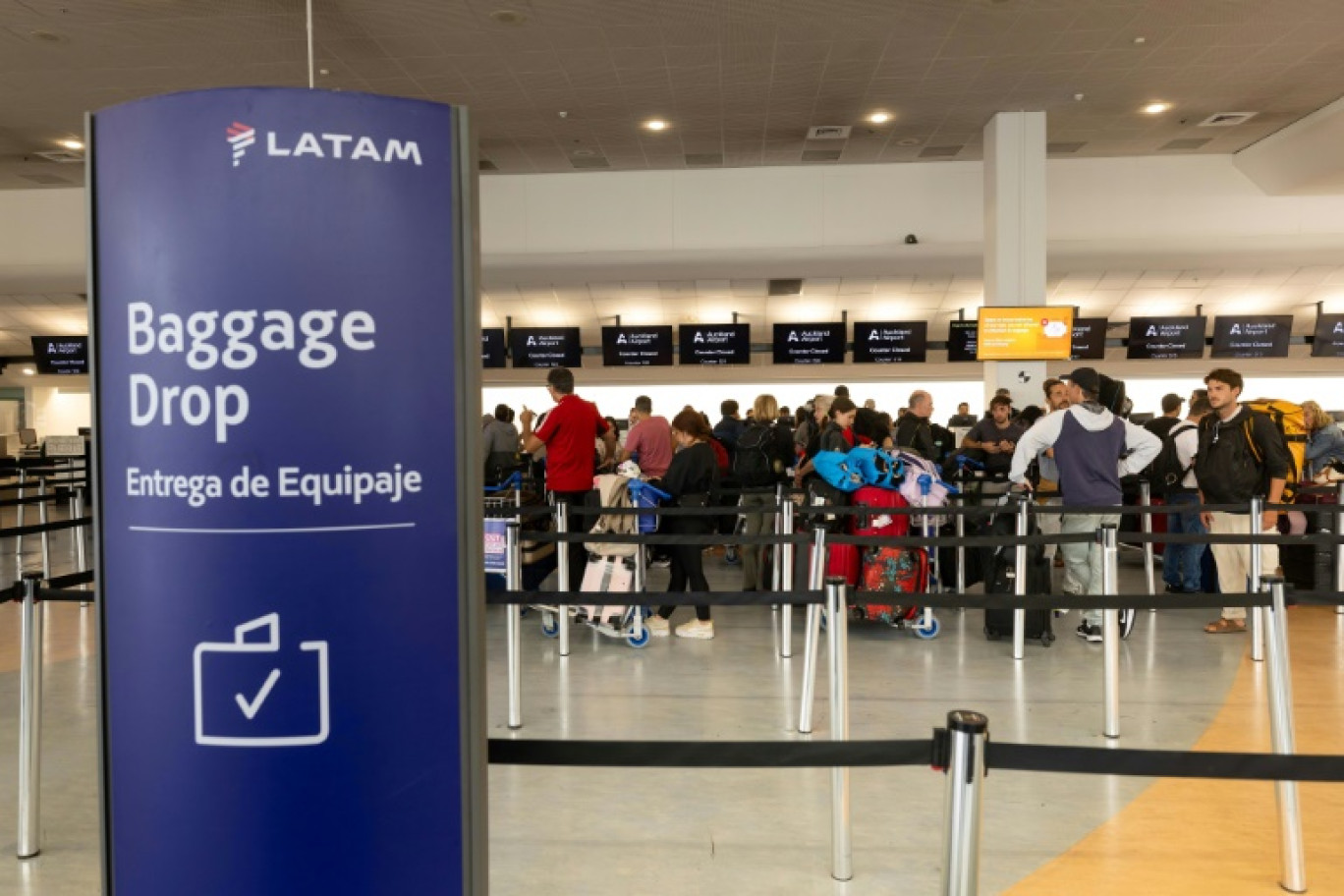 Des voyageurs au comptoir de la Latam Airlines à l'aéroport d'Auckland, au lendemain d'un "incident" technique sur un Boeing 787 de la compagnie, le 12 mars 2024 en Nouvelle-Zélande © BRETT PHIBBS