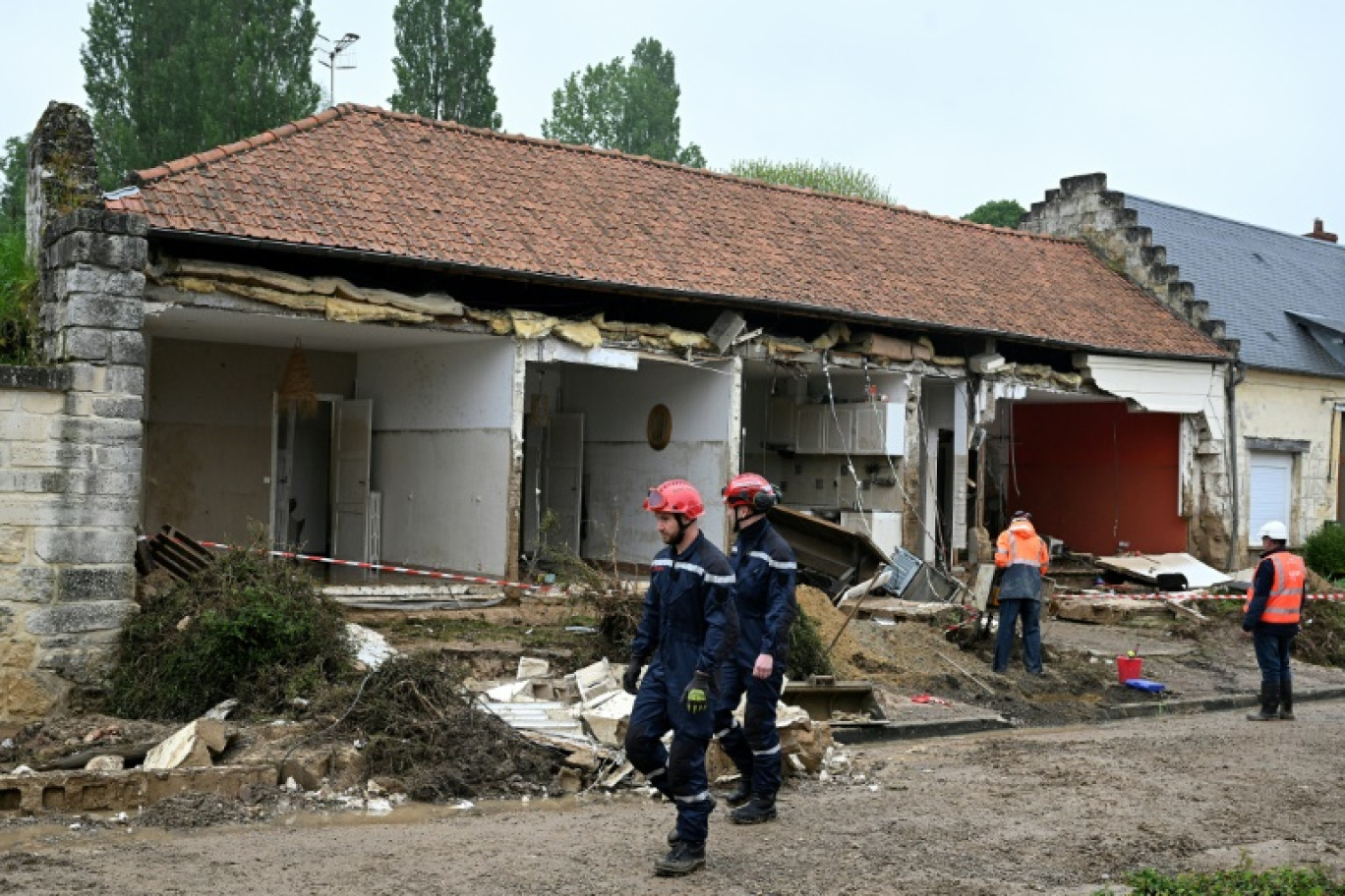 Des pompiers devant une maison éventrée par une coulée de boue pendant des orages, provoquant le décès d'une femme, le 2 mai 2024 à Courmelles, dans l'Aisne © FRANCOIS NASCIMBENI