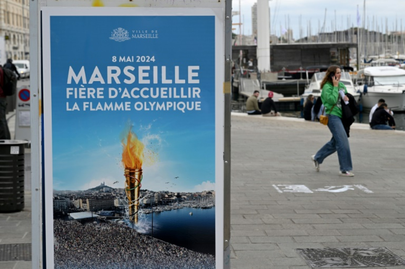 Une affiche "Marseille est fière d'accueillir la flamme olympique" sur le Vieux-Port, le 6 mai 2024 à Marseille © Nicolas TUCAT