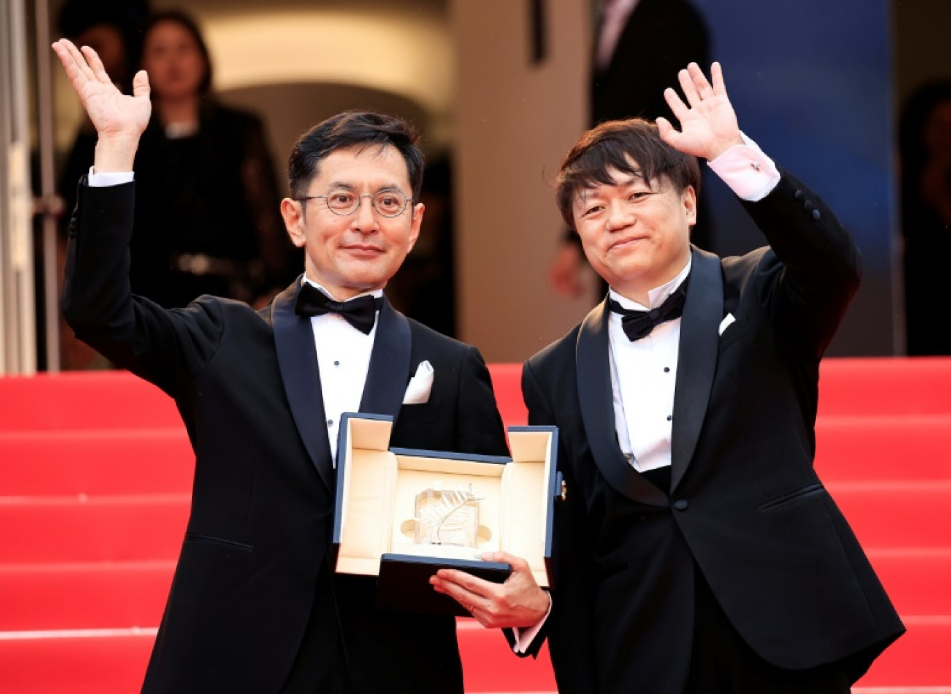 Le vice-président Kenichi Yoda (d) et le réalisateur japonais Gorö Miyazaki montrent la Palme d'or d'honneur décernée au studio d'animation japonais Ghibli, lors du 77e Festival de Cannes, le 20 mai 2024 © Valery HACHE