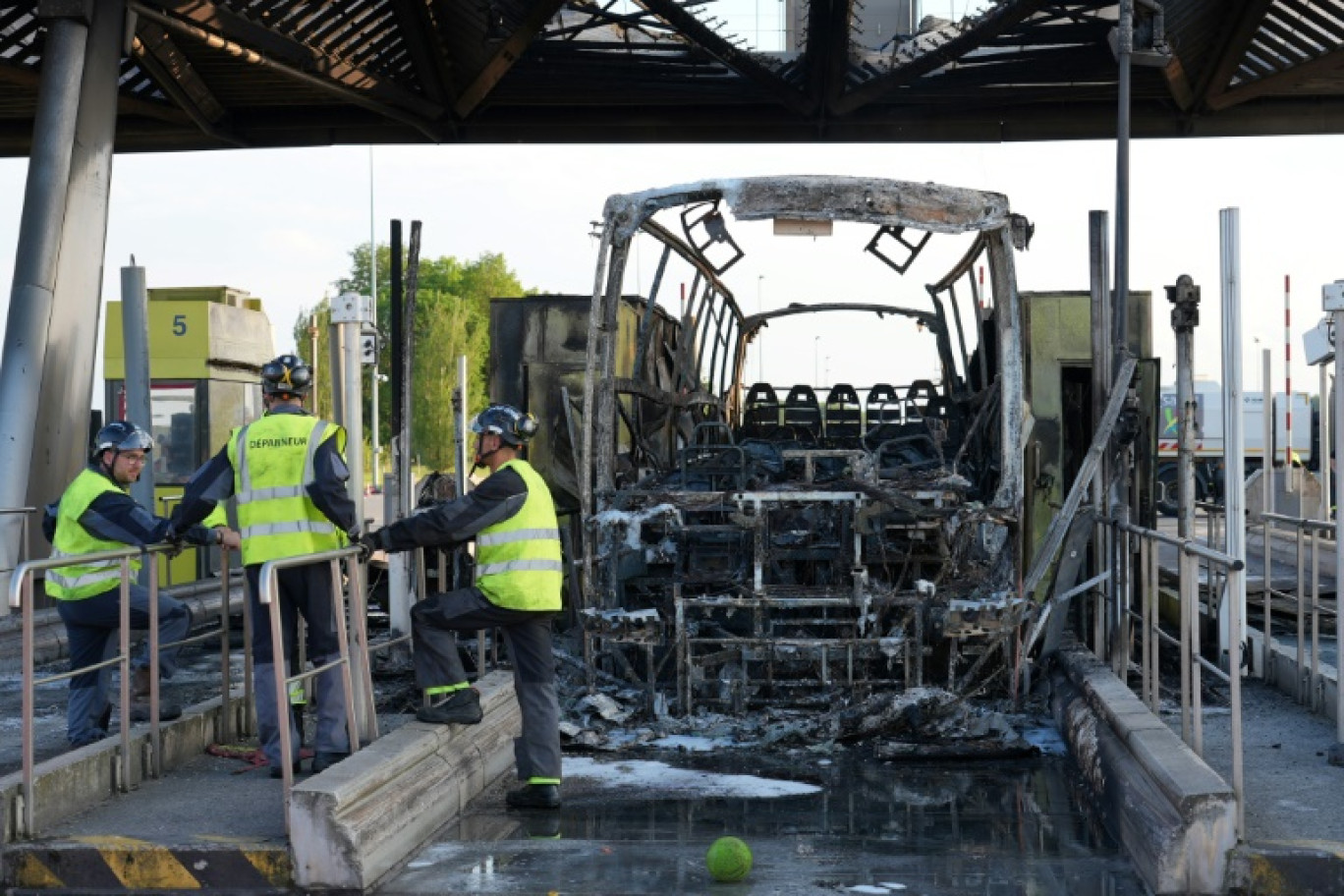 Un autocar calciné après des affrontements entre fans de l'OL et du PSG à un péage d'autoroute, juste avant la finale de la Coupe de France à Lille, le 25 mai 2024 au péage de Fresnes-lès-Montauban, dans le Pas-de-Calais © Pierre BEAUVILLAIN