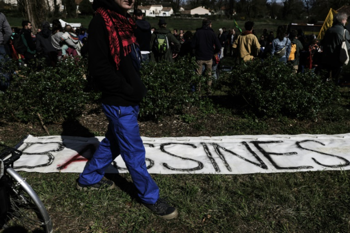 Un manifestant devant une banderole "Bassines" à Melle le 23 mars 2024 © Thibaud MORITZ