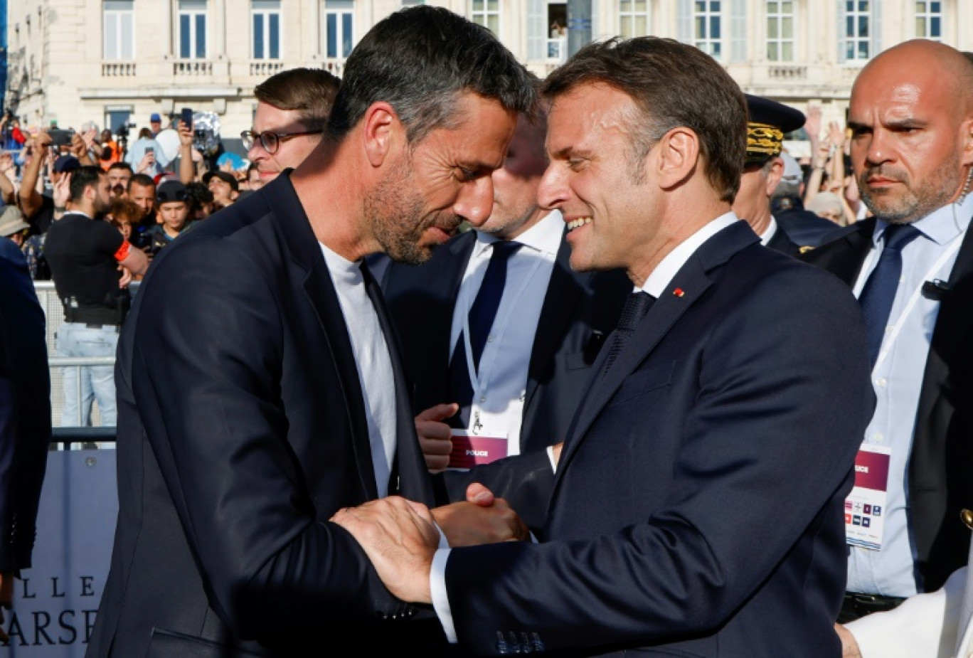 Le patron du comité d'organisation de Paris 2024 Tony Estanguet (G) serre la main du président Emmanuel Macron à l'arrivée de la flamme olympique à Marseille le 8 mai 2024 © Ludovic MARIN