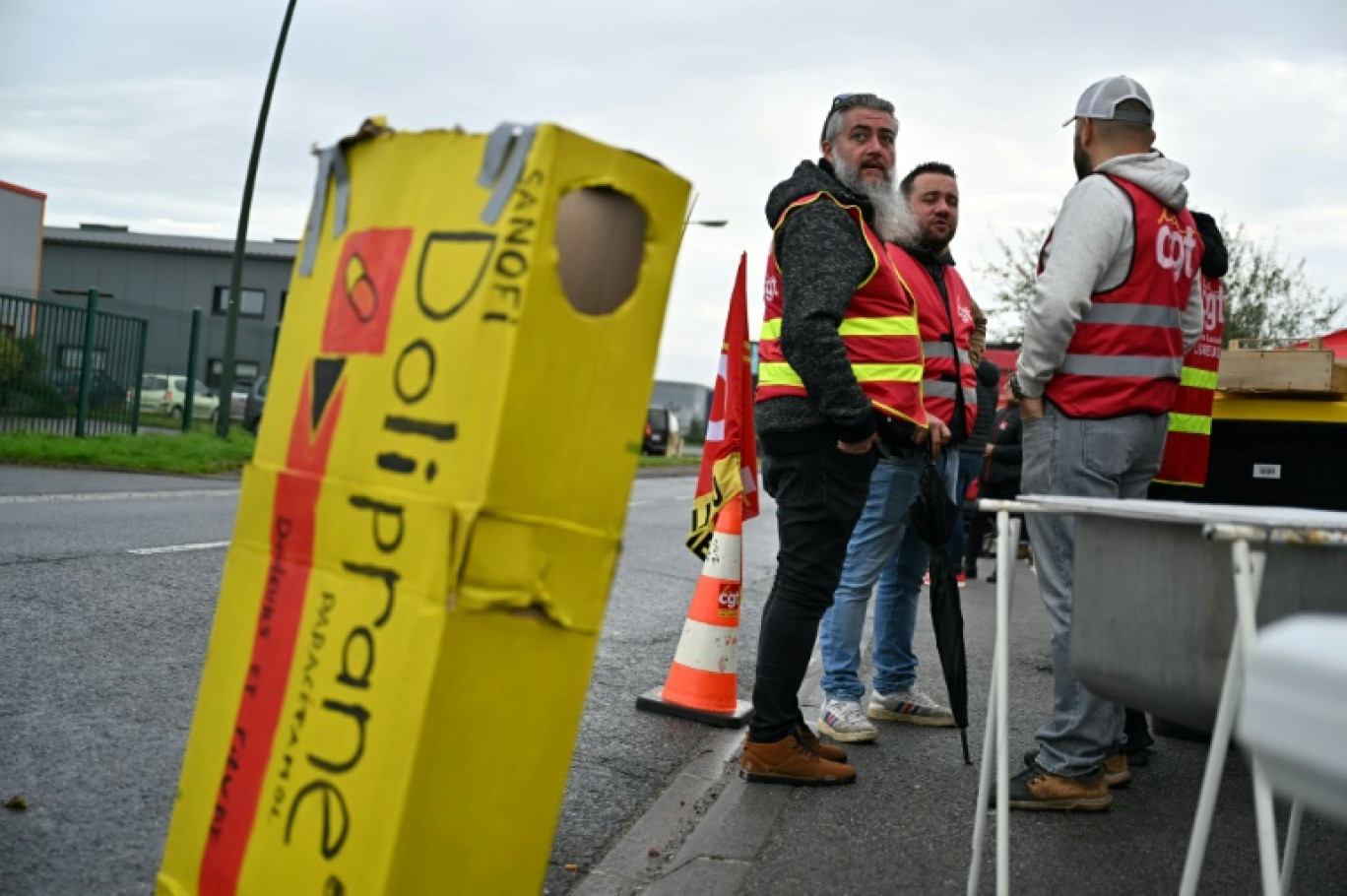 Des employés et des syndicalistes en grève devant leur usine qui fabrique le Doliprane à Lisieux (nord-ouest de la France), après l'annonce par Sanofi de négociation en cours avec le fonds d'investissement américain CD&R afin de lui céder potentiellement 50% de la d'Opella, sa filiale qui commercialise notamment ce paracétamol en France. Photo prise le 17 octobre © LOU BENOIST