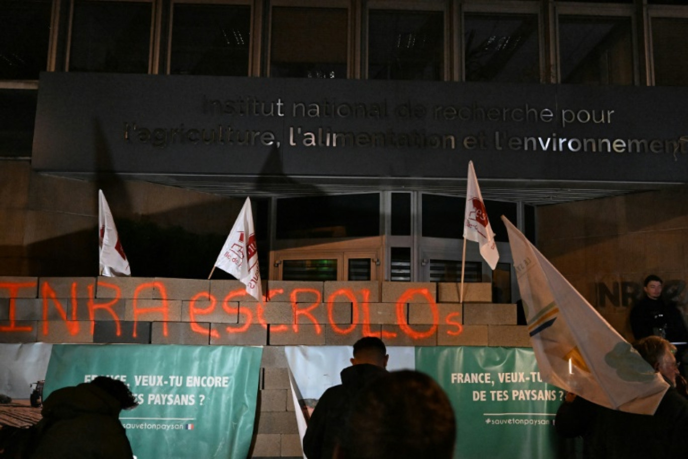 Des agriculteurs devant l'Inrae après avoir érigé un mur en parpaings devant l'institut, le 28 novembre 2024, à Paris © Gregoire CAMPIONE