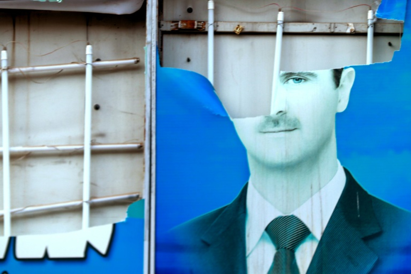 Un portrait déchiré du président syrien Bashar al-Assad à Qamishli, alors que les Kurdes syriens célèbrent la chute de Damas aux mains des groupes rebelles, le 8 décembre 2024 © Delil SOULEIMAN