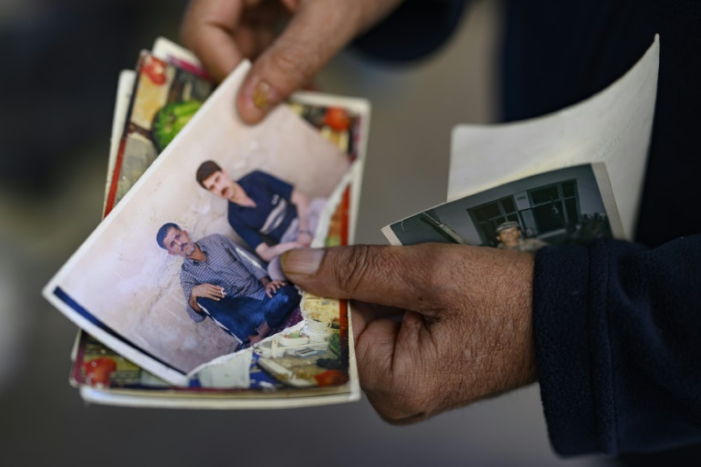 Le Turc Mehmet Erturk, tout juste libéré d'une prison syrienne, montre une photo de lui et de son ami Faruk Karga, lors d'un entretien avec l'AFP dans sa maison du village de Magaracik, le 13 décembre 2024 à Kilis, en Turquie © Yasin AKGUL