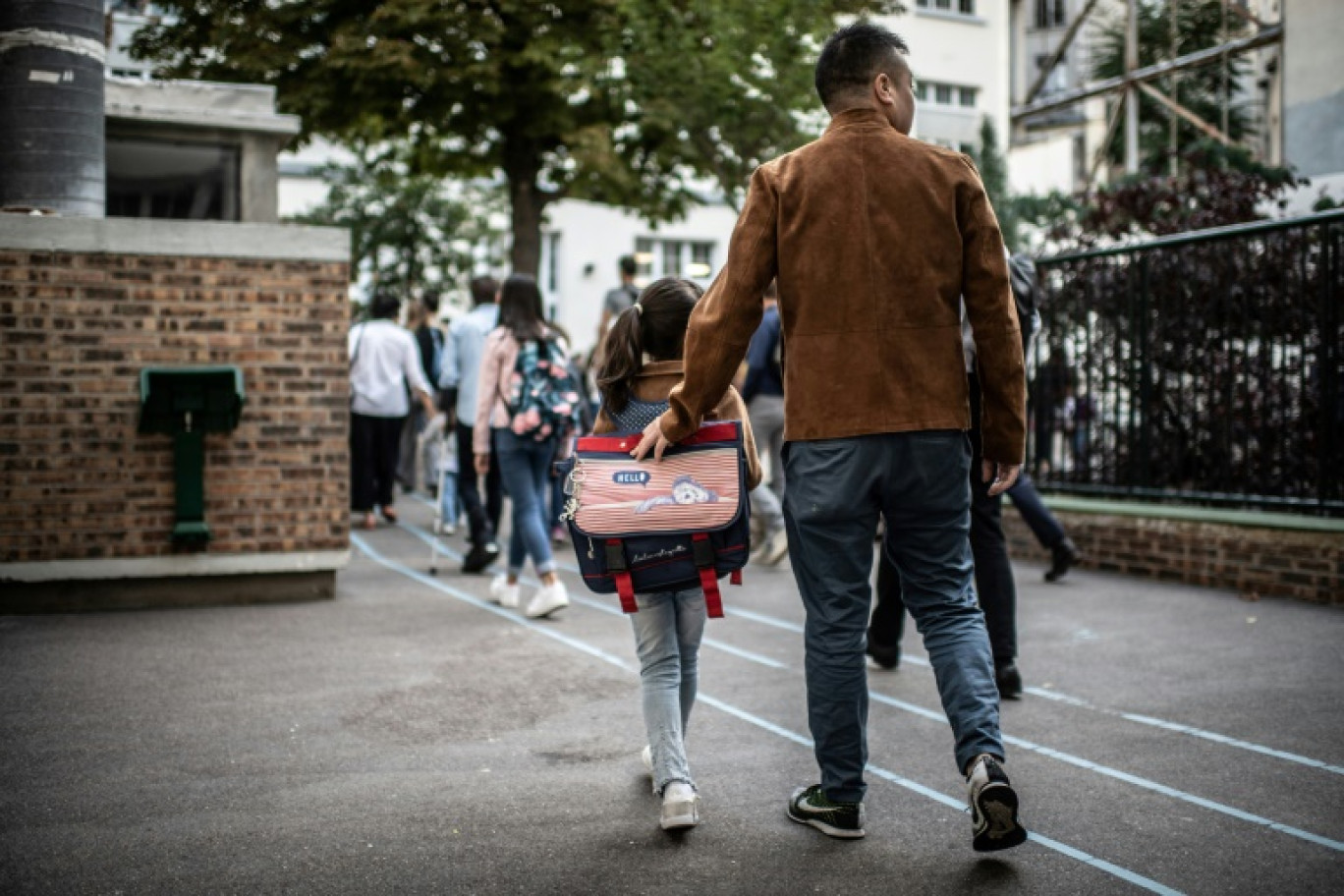 Un père accompagne sa fille à l'école à l'occasion de la rentrée scolaire à Paris le 2 septembre 2019 © Martin BUREAU