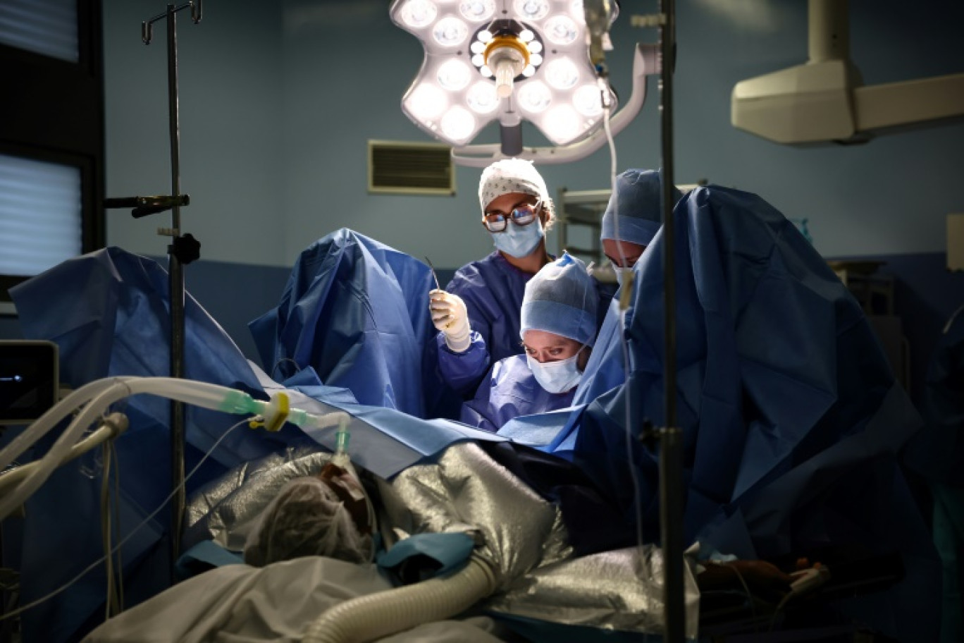 La chirurgienne Sarah Abramowicz (c) et ses assistants procèdent à une chirurgie reconstructive sur une patiente ayant subi une mutilation génitale féminine (MGF), à l'hôpital André Grégoire de Montreuil, près de Paris, le 4 mars 2025 © Anne-Christine POUJOULAT