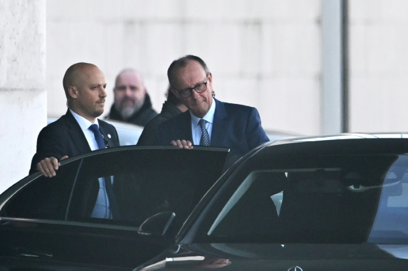 Friedrich Merz (c), chef de file des démocrates-chrétiens allemands et futur chancelier, monte en voiture après une réunion à la chancellerie, le 5 mars 2025 à Berlin © RALF HIRSCHBERGER