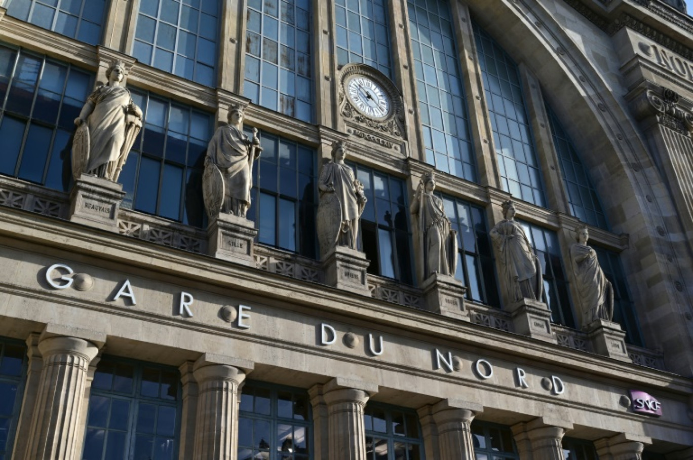 Des passagers sous les écrans d'information affichant que l'arrêt du trafic à la gare du Nord à Paris le 7 mars 2025, suite à la découverte d'une bombe de la Seconde Guerre mondiale © GEOFFROY VAN DER HASSELT