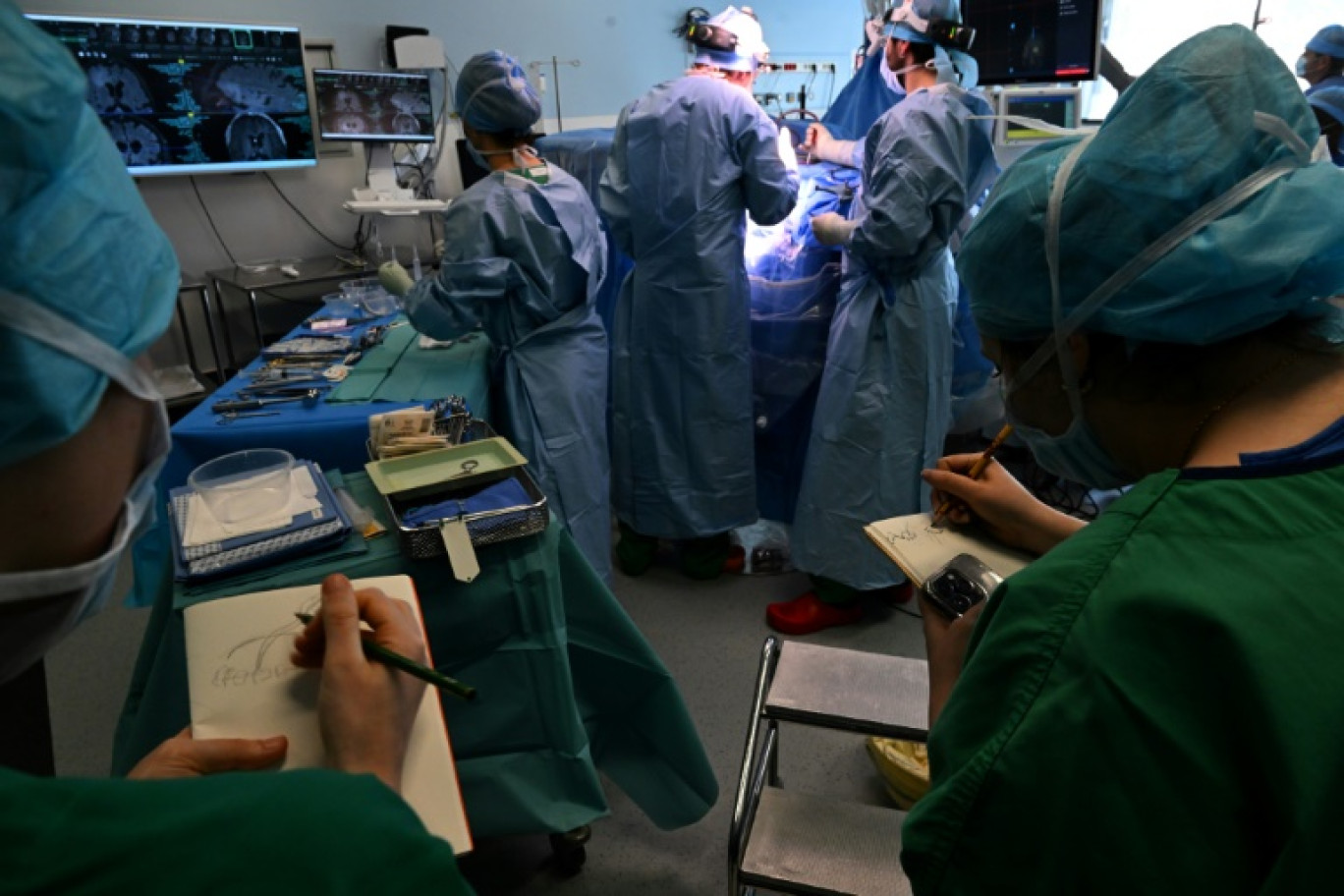 Des étudiants de l'Ecole Supérieure d'Art et de Design (Esad) dessinent pendant une opération du cerveau sur un patient éveillé atteint d'une tumeur cérébrale, dans le cadre d'un programme interdisciplinaire franco-allemand en neurochirurgie, le 5 mars 2025 au CHU de Reims © FRANCOIS NASCIMBENI