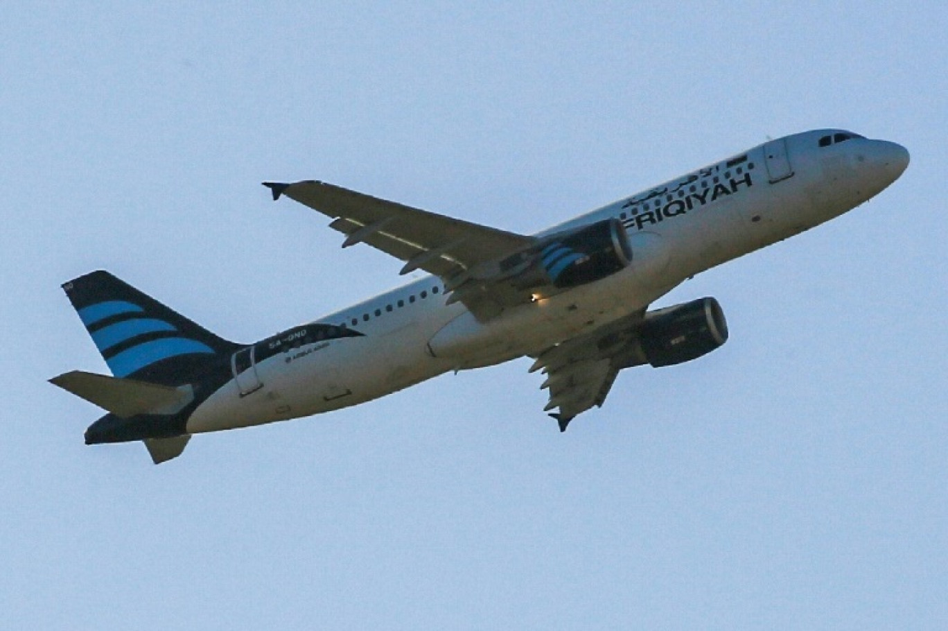 Un avion Airbus A320 de la compagnie Afriqiyah Airways survole l'aéroport international de Mitiga, à l'est de Tripoli, le 12 décembre 2019 en Libye © Mahmud TURKIA