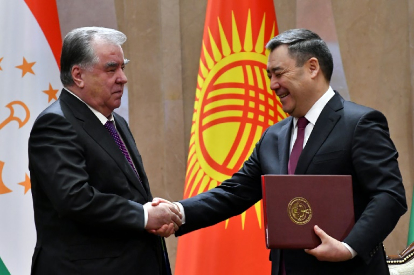 Le président kirghiz Sadyr Japarov et son homologue tadjik Emomali Rakhmon se serrent la main, après la signature d'un accord frontalier crucial pour la stabilité de l'Asie centrale, après trois décennies de conflits entre ces deux ex-républiques soviétiques notamment pour le contrôle de l'eau. Photo prise à Bichkek le 13 mars 2025 © VYACHESLAV OSELEDKO