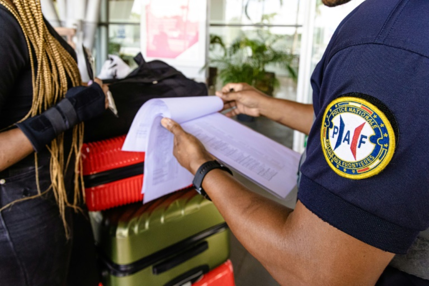 Un policier de la PAF contrôle une passagère à l'aéroport international Félix-Eboué de Cayenne, le 14 octobre 2022 © jody amiet