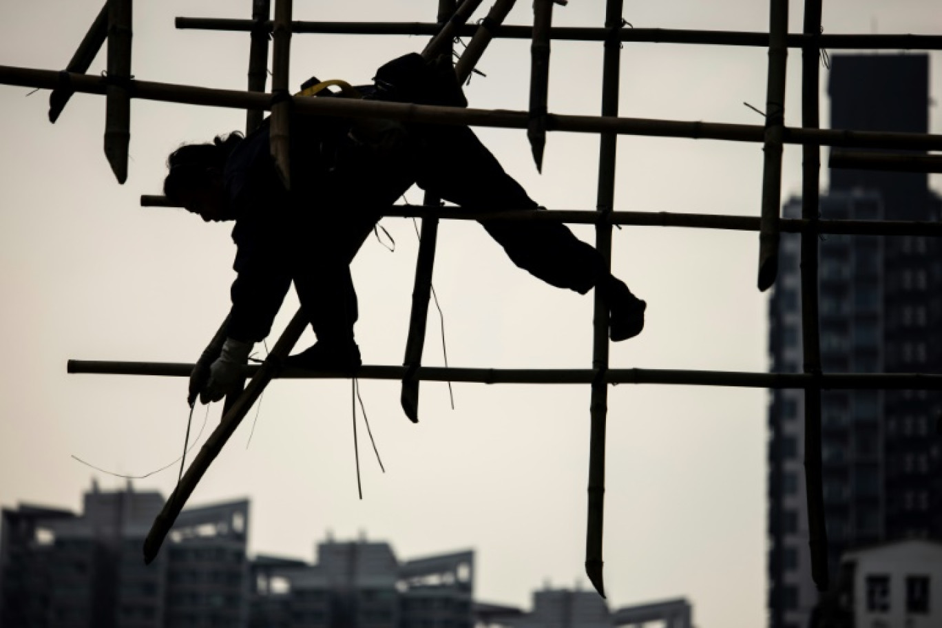 Un ouvrier construit un échafaudage en bambou, le 9 mars 2023 à Hong Kong © ISAAC LAWRENCE