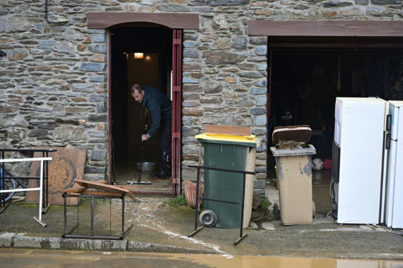 Un homme nettoie la boue dans une maison inondée, à Guipry-Messac (Ille-et-Vilaine), le 3 février 2025 © Damien MEYER