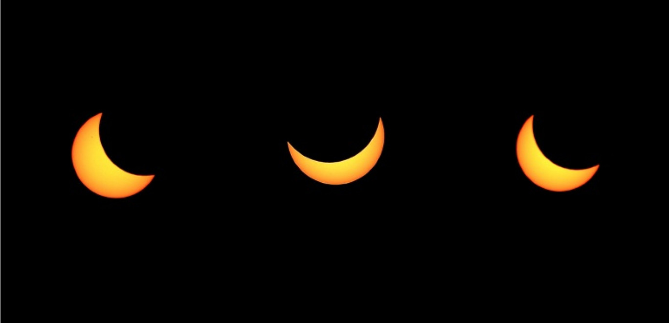 Une combinaison de trois images montre la progression d'une éclipse solaire partielle le 20 mars 2015 au-dessus de Strasbourg © FREDERICK FLORIN