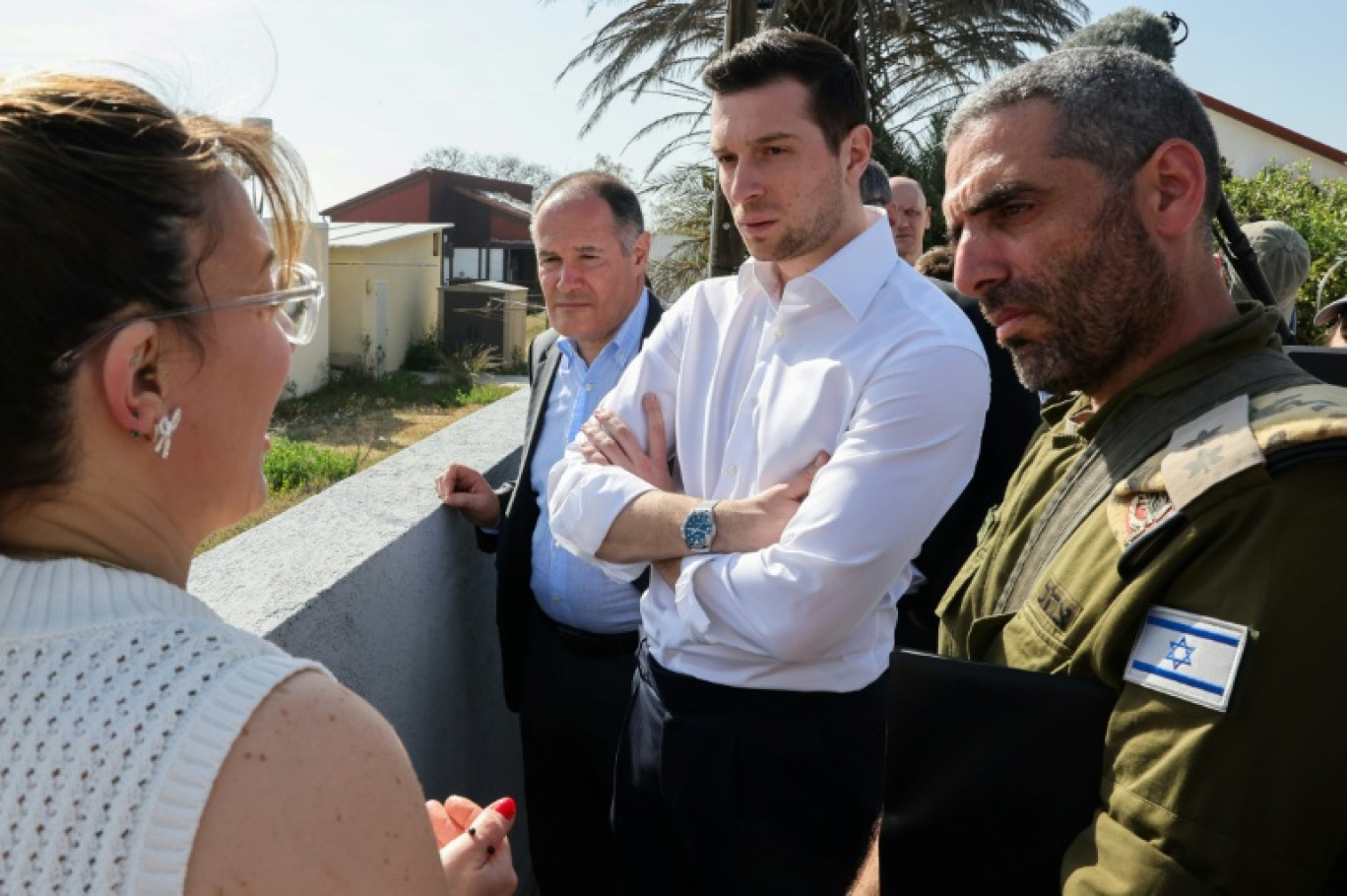 Sabine Tassa (g), survivante de l'attaque du 7 octobre 2023, échange avec le président du Rassemblement national (RN) Jordan Bardella (c), le 26 mars 2025 à Netiv Haasara, en Israël © Jack GUEZ
