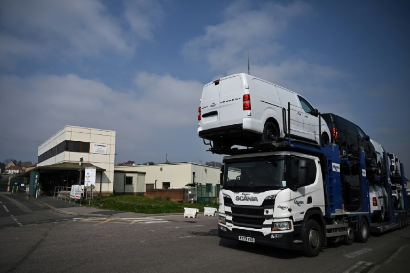 Un camion transportant des véhicules neufs sort de l'usine Vauxhall, à Luton, au nord de Londres, le 24 mars 2025 © Ben STANSALL