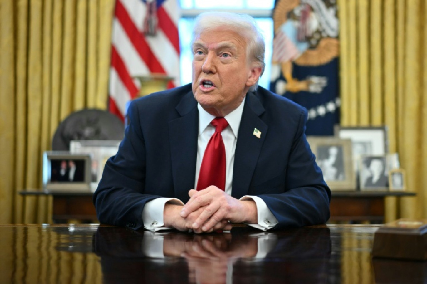 Le président américain Donald Trump montre le décret des droits de douane sur les automobiles qu'l vient de signer dans le Bureau ovale de la Maison Blanche, le 26 mars 2025 à Washington © Mandel NGAN