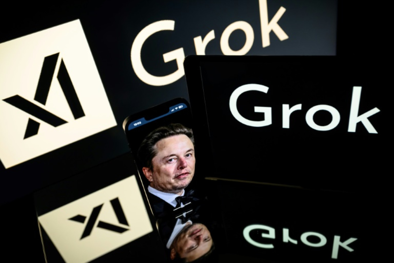 Elon Musk entre des logos de sa start-up xAI et de son robot conversationnel d'IA générative Grok, le 13 janvier 2025 © Lionel BONAVENTURE