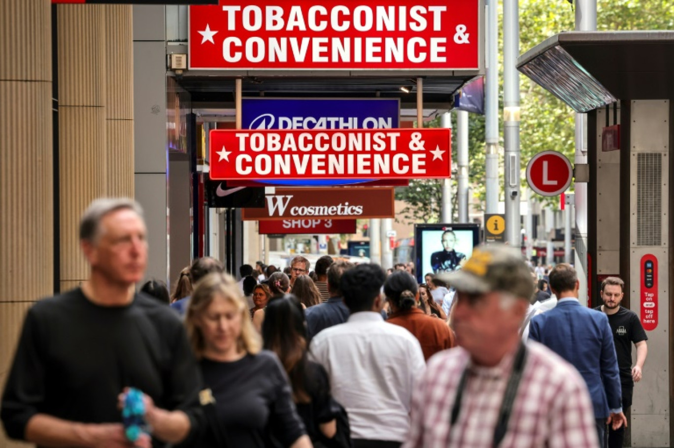 Des piétons passent devant un bureau de tabac à Sydney, en Australie, le 27 mars 2025 © DAVID GRAY