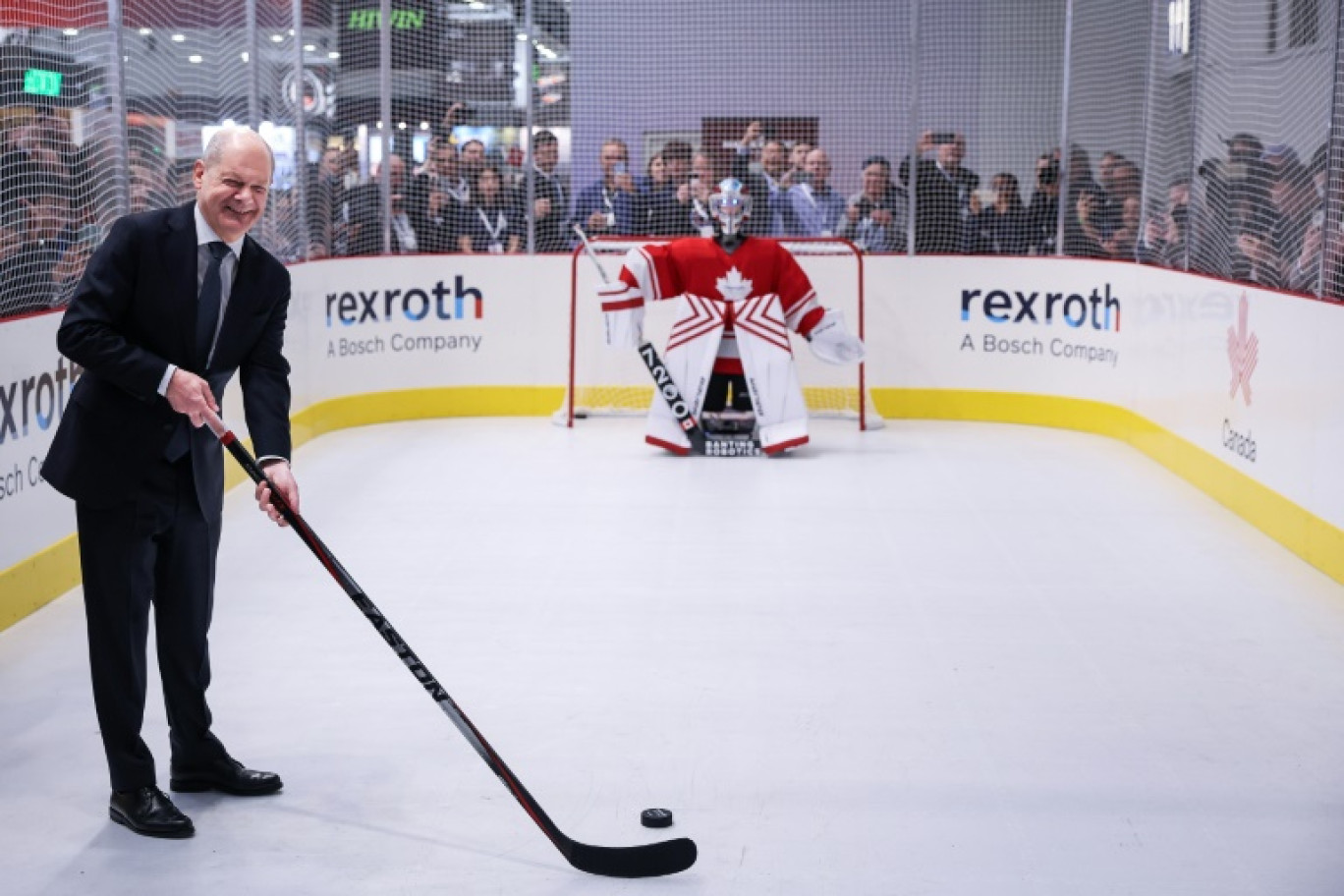 Le chancelier allemand Olaf Scholz pose sur un terrain de hockey factice à la foire industrielle de Hanovre, en Allemagne, dont le Canada est l'invité d'honneur, jusqu'au 4 avril © RONNY HARTMANN