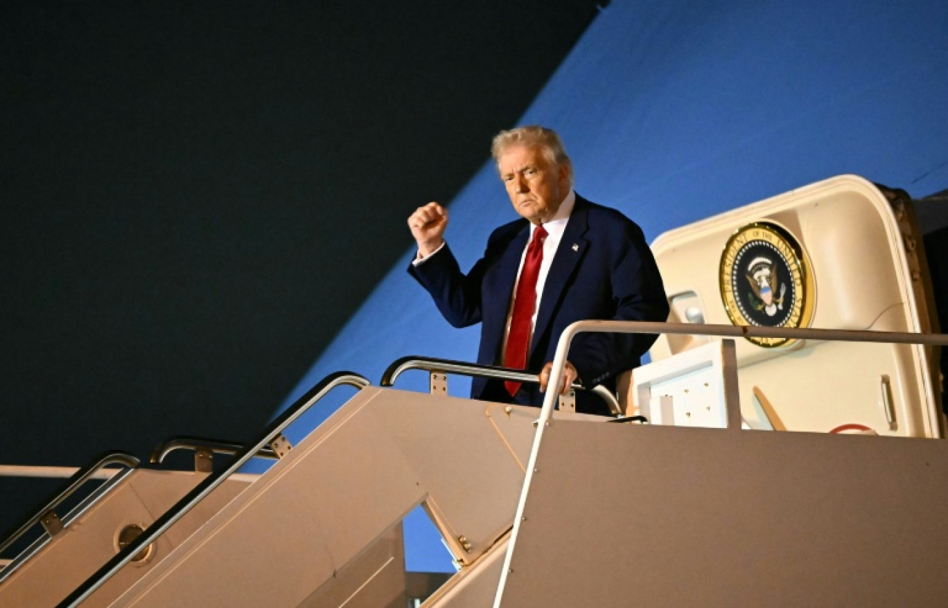 Le président américain Donald Trump lève le poing à l'entrée de son avion, le 3 avril 2025 à West Palm Beach (Etats-Unis) © Mandel NGAN